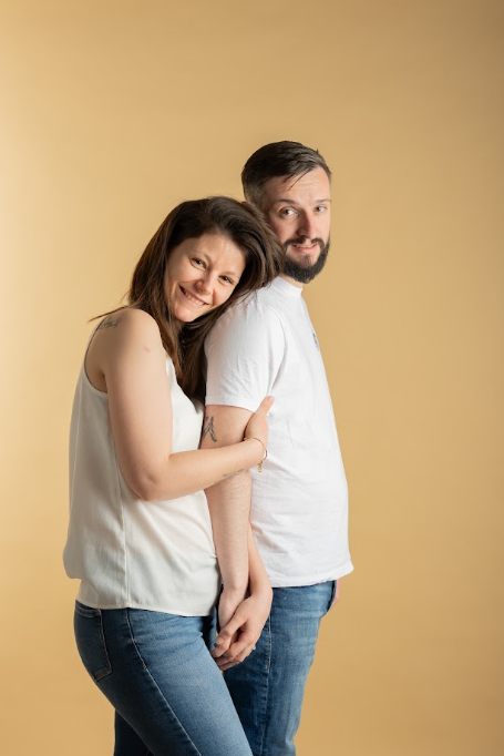 Couple enlacé de dos en studio sur fond ocre