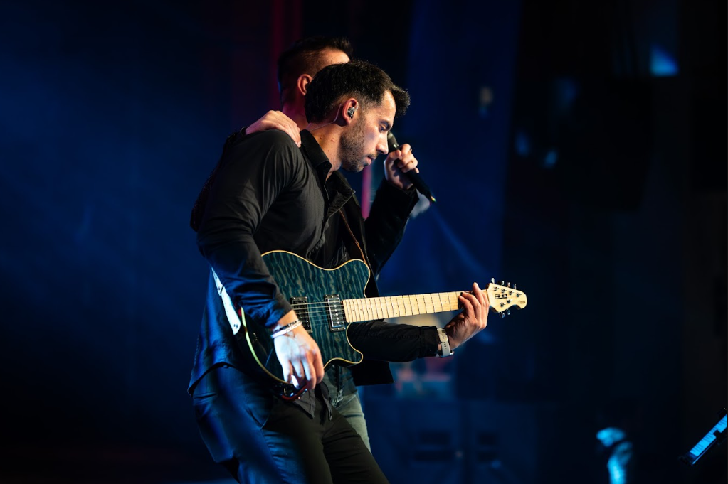 Guitariste et chanteur épaule contre épaule en concert