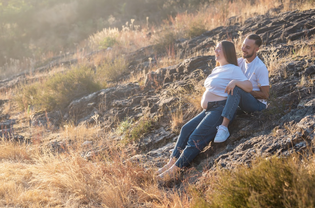 Couple attendant un enfant, assis sur des rochers