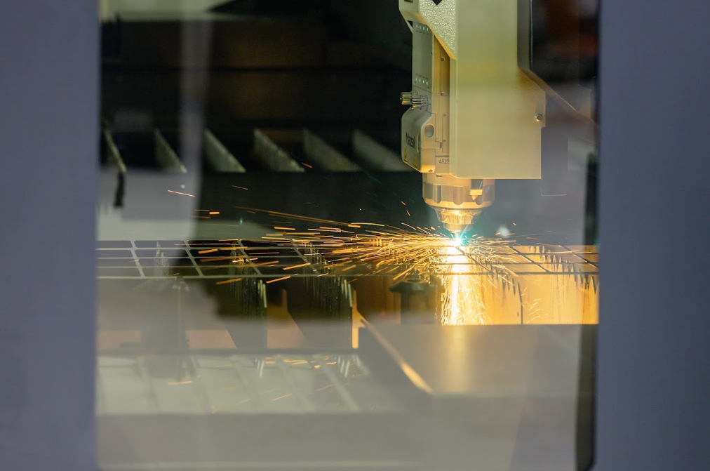 Découpe laser en action derrière une vitre de protection