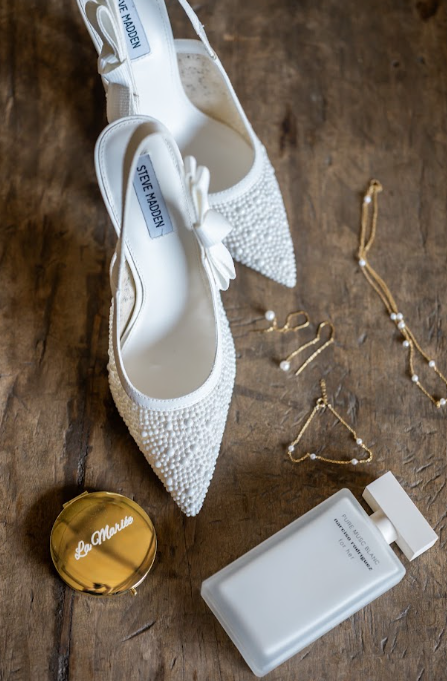 Escarpins perlés, bijoux et parfum de la mariée sur bois