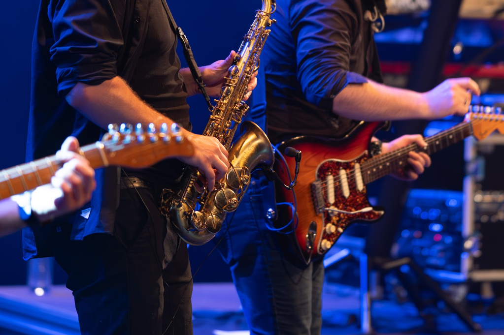 Détail de mains de guitaristes et d'un saxophoniste sur scène