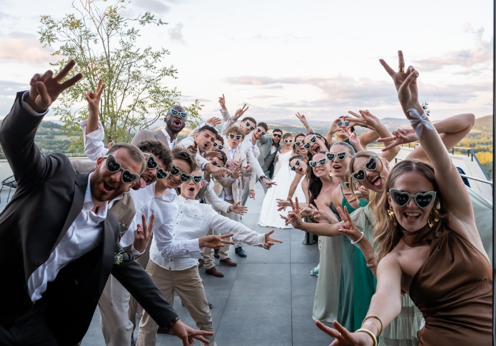 Photo de groupe des invités en lunettes cœur au coucher du soleil