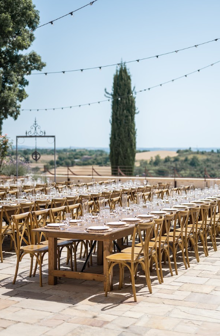 Grandes tablées dressées en terrasse sous les guirlandes