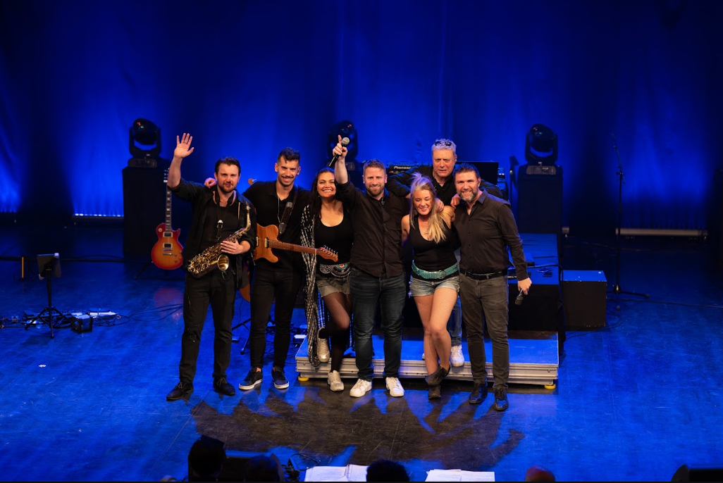 Groupe de musiciens saluant le public en fin de concert
