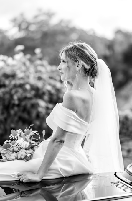 Portrait de la mariée assise sur une voiture, noir et blanc